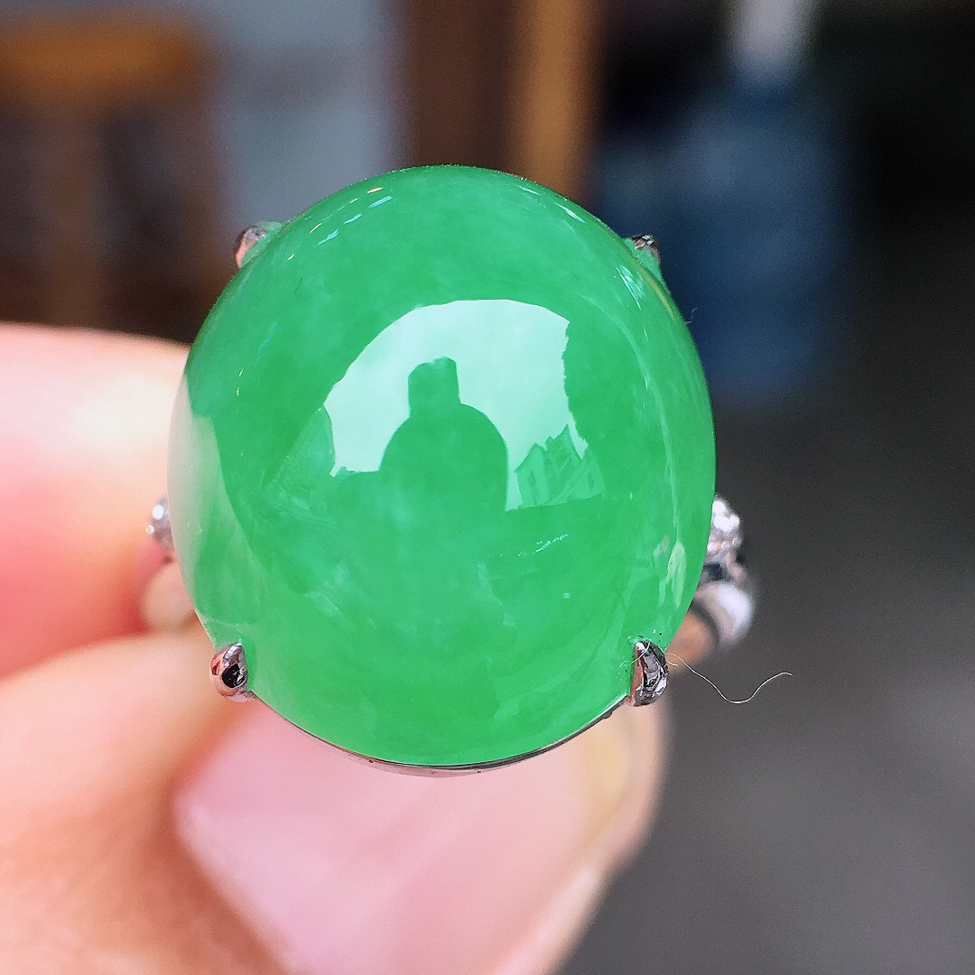 阳绿蛋面戒指，色泽均匀艳丽，玉质细腻，荧光感超
强，饱满圆润，尽显优雅气质，18k
金豪华镶嵌