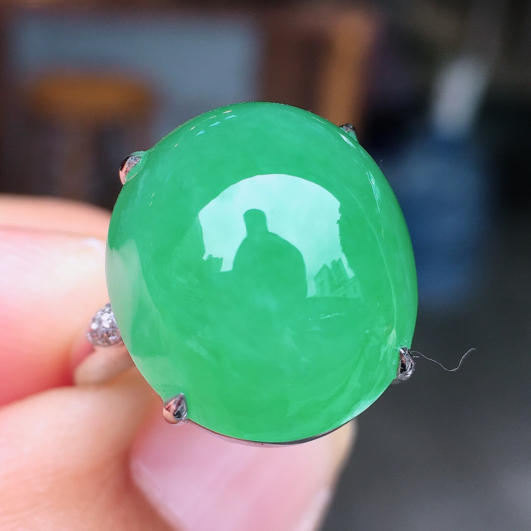 阳绿蛋面戒指，色泽均匀艳丽，玉质细腻，荧光感超
强，饱满圆润，尽显优雅气质，18k
金豪华镶嵌