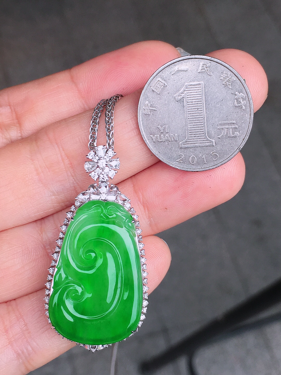 阳绿如意吊坠，色泽均匀艳丽，玉质细腻，荧光感超
强，饱满圆润，尽显优雅气质，18k
金豪华镶嵌