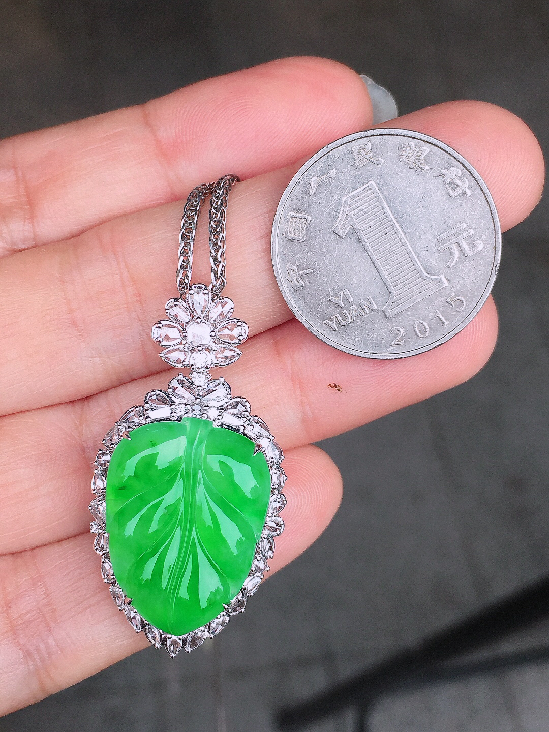 阳绿玉叶吊坠，色泽均匀艳丽，玉质细腻，荧光感超
强，饱满圆润，尽显优雅气质，18k
金豪华镶嵌
