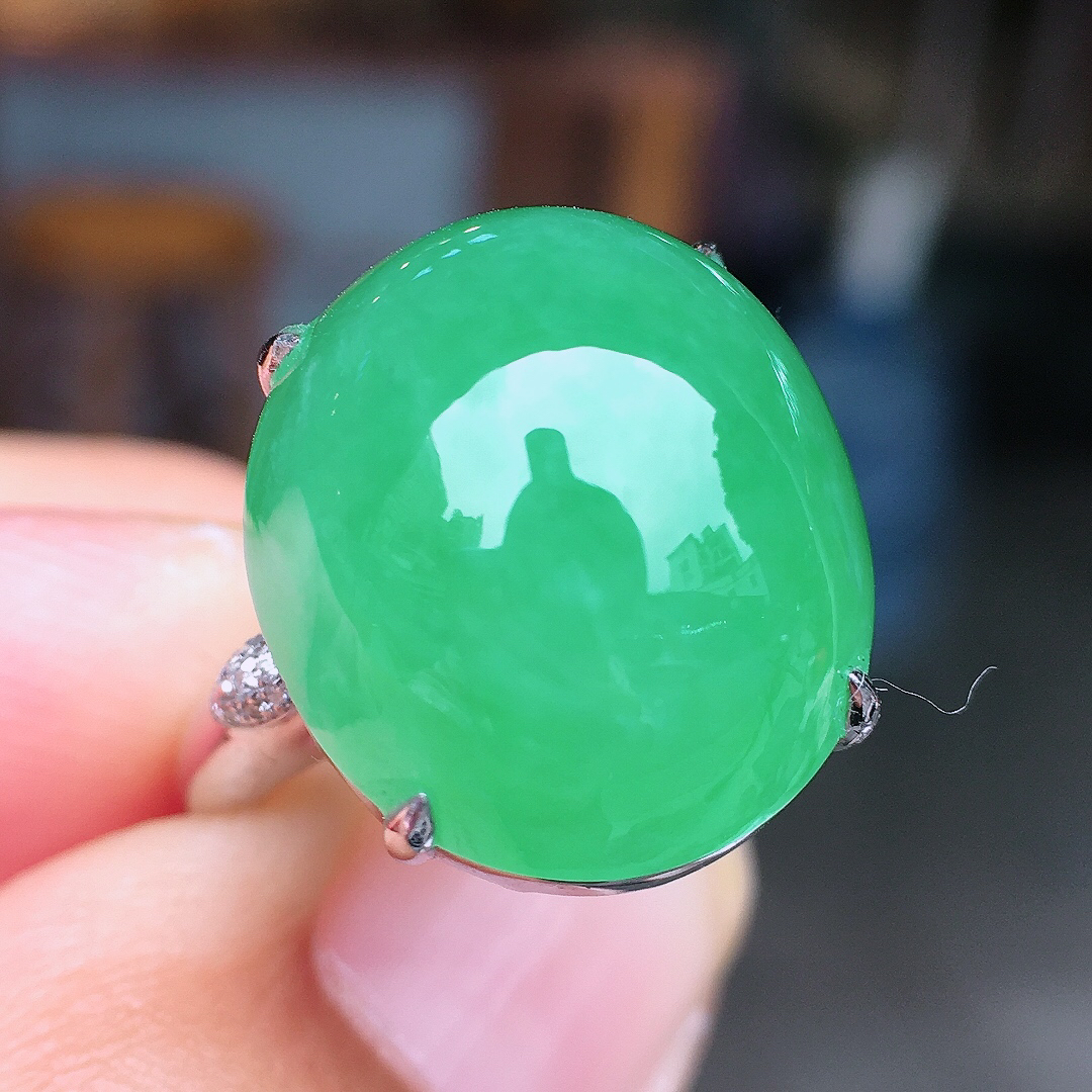 阳绿蛋面戒指，色泽均匀艳丽，玉质细腻，荧光感超
强，饱满圆润，尽显优雅气质，18k
金豪华镶嵌