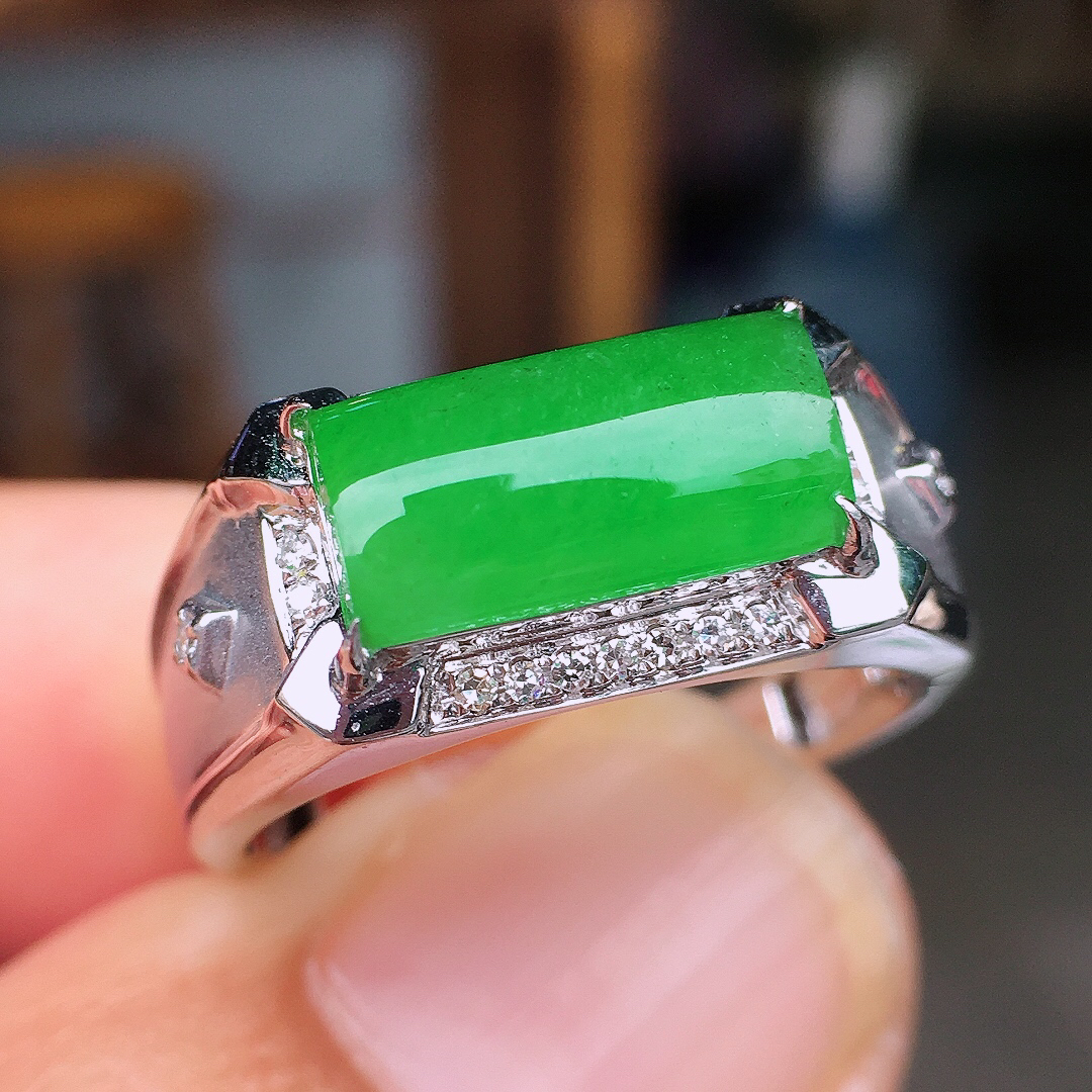 阳绿马鞍戒指，色泽均匀艳丽，玉质细腻，荧光感超
强，饱满圆润，尽显优雅气质，18k
金豪华镶嵌