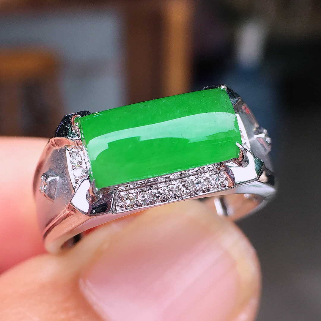 阳绿马鞍戒指，色泽均匀艳丽，玉质细腻，荧光感超
强，饱满圆润，尽显优雅气质，18k
金豪华镶嵌