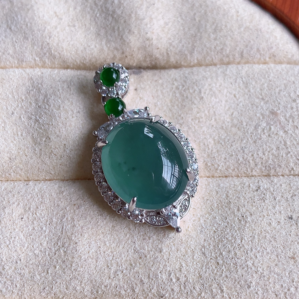 冰晴水蛋面翡翠吊坠，质地细腻，清秀高雅，饱满圆润  款式大方经典，颜色鲜艳，沁人心脾，高质量精品   925银饰镶嵌 W502.8 整体尺寸：27.5-15-9mm   裸石尺寸：14-11.5mm