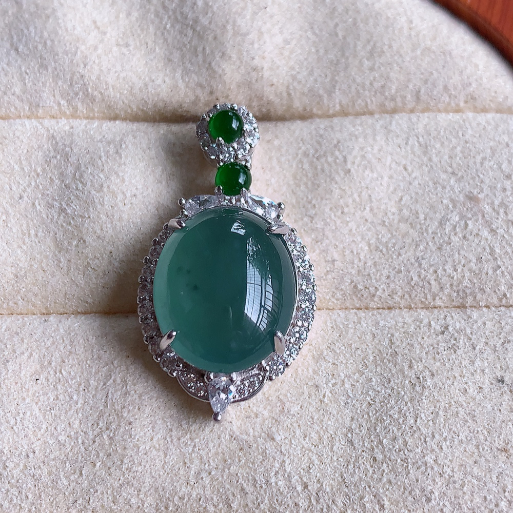 冰晴水蛋面翡翠吊坠，质地细腻，清秀高雅，饱满圆润  款式大方经典，颜色鲜艳，沁人心脾，高质量精品   925银饰镶嵌 W502.8 整体尺寸：27.5-15-9mm   裸石尺寸：14-11.5mm