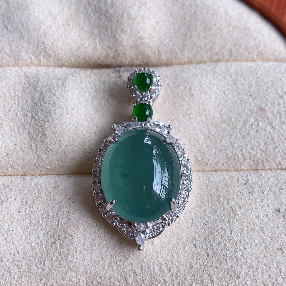 冰晴水蛋面翡翠吊坠，质地细腻，清秀高雅，饱满圆润  款式大方经典，颜色鲜艳，沁人心脾，高质量精品   925银饰镶嵌 W502.8 整体尺寸：27.5-15-9mm   裸石尺寸：14-11.5mm