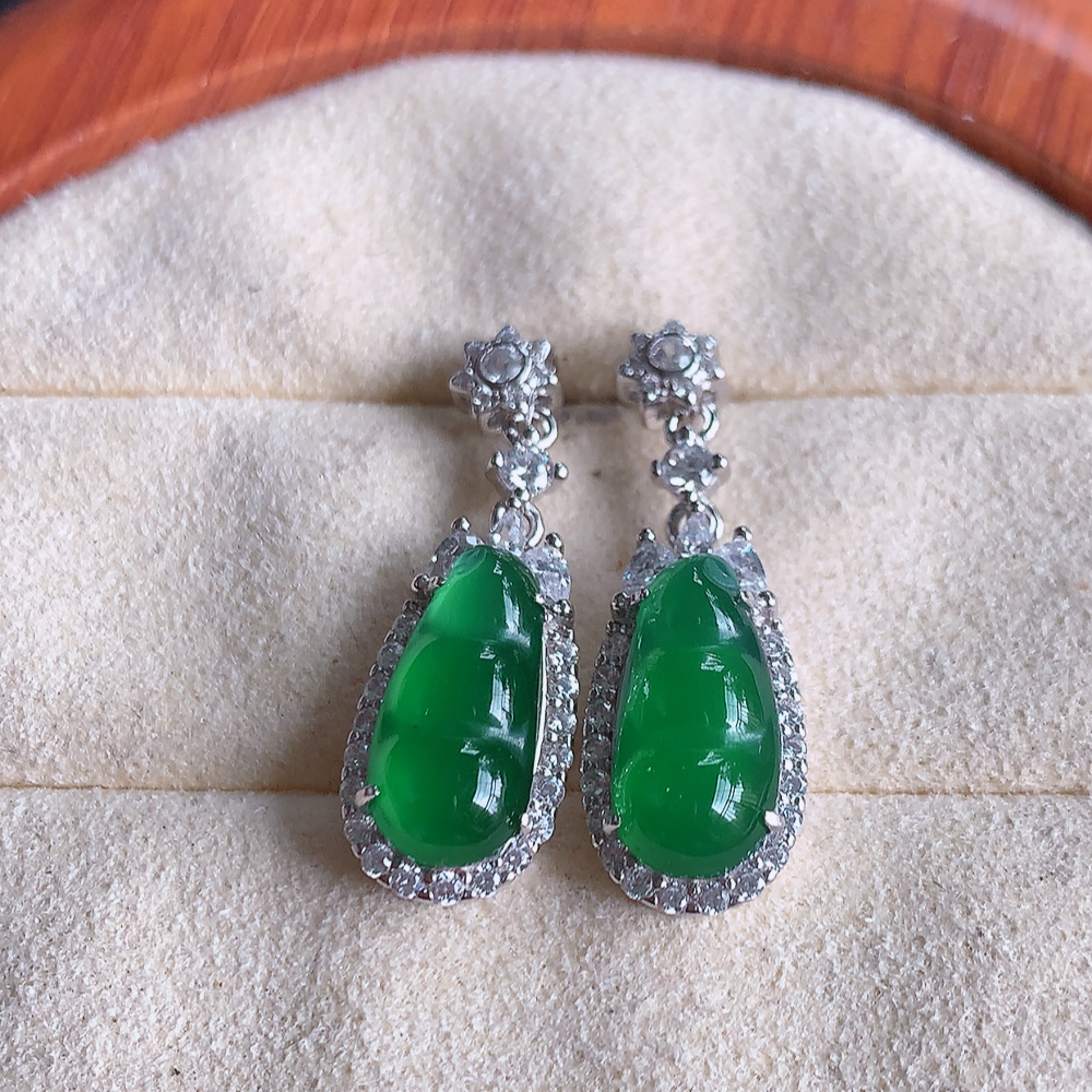 冰满绿翡翠925银镶嵌福豆耳钉，自然光实拍，翠色灵动，颜色漂亮，种老水足，品相佳，佩戴佳品！W481.8  取一整体尺寸：26.5-9-6.2mm  裸石尺寸：13.3-6.2mm