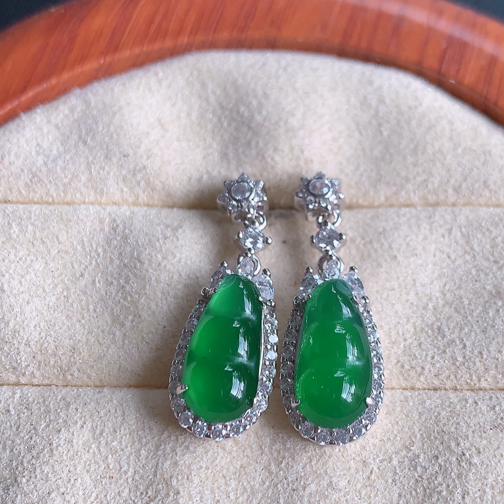 冰满绿翡翠925银镶嵌福豆耳钉，自然光实拍，翠色灵动，颜色漂亮，种老水足，品相佳，佩戴佳品！W481.8  取一整体尺寸：26.5-9-6.2mm  裸石尺寸：13.3-6.2mm