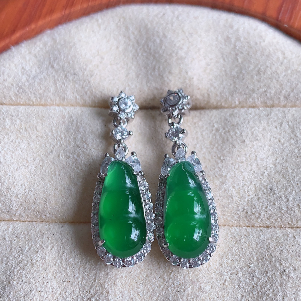 冰满绿翡翠925银镶嵌福豆耳钉，自然光实拍，翠色灵动，颜色漂亮，种老水足，品相佳，佩戴佳品！W481.8  取一整体尺寸：26.5-9-6.2mm  裸石尺寸：13.3-6.2mm