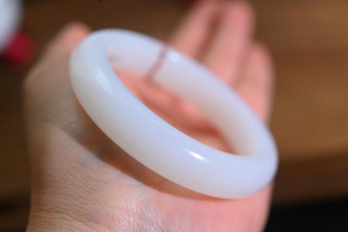 羊52羊脂白玉手镯和田玉山料手镯52圈口宽12厚9无裂无杂无水线特细腻 高脂粉，高品质，萦绕腕间时，古韵不失时尚，素雅不失品味，细腻光滑的触感，使人沉醉，气质高雅 魅力动人