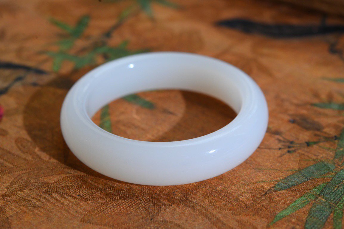 羊54羊脂白玉手镯和田玉山料手镯54圈口宽12.2厚9无裂无杂无水线特细腻 高脂粉，高品质，萦绕腕间时，古韵不失时尚，素雅不失品味，细腻光滑的触感，使人沉醉，气质高雅 魅力动人