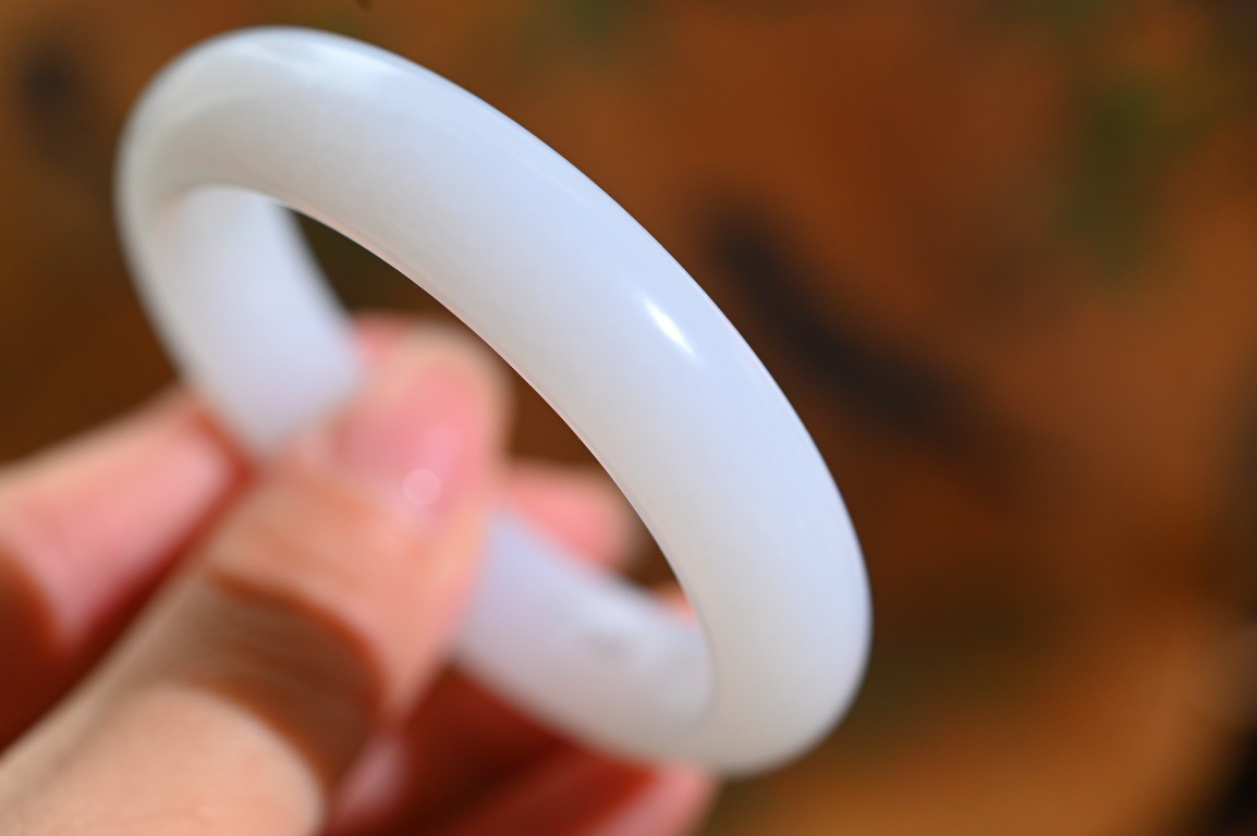 羊59羊脂白玉手镯和田玉山料手镯59圈口宽12厚9无裂无杂无水线特细腻 高脂粉，高品质，萦绕腕间时，古韵不失时尚，素雅不失品味，细腻光滑的触感，使人沉醉，气质高雅 魅力动人