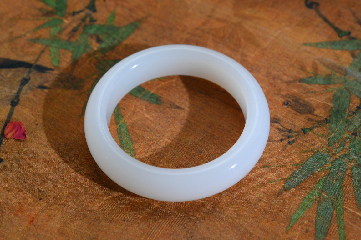 羊54羊脂白玉手镯和田玉山料手镯54圈口宽12.2厚9无裂无杂无水线特细腻 高脂粉，高品质，萦绕腕间时，古韵不失时尚，素雅不失品味，细腻光滑的触感，使人沉醉，气质高雅 魅力动人