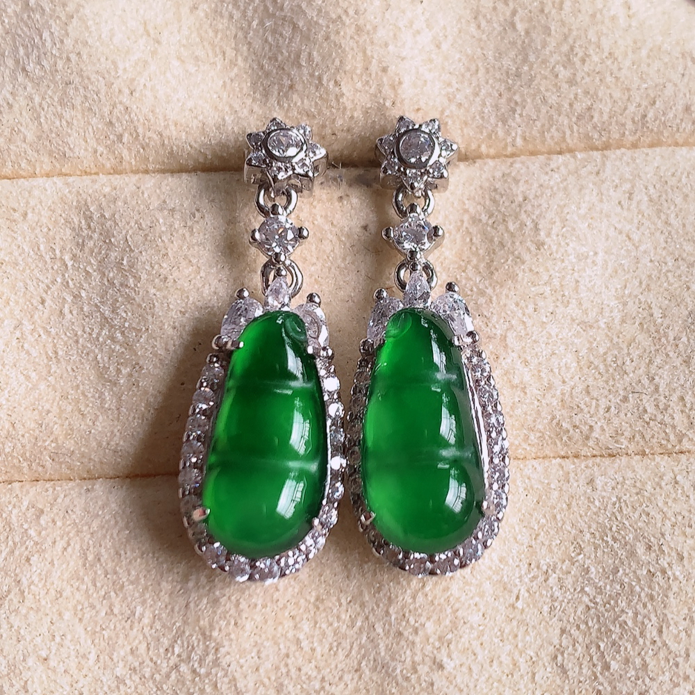 冰满绿翡翠925银镶嵌福豆耳坠，自然光实拍，翠色灵动，颜色漂亮，种老水足，品相佳，佩戴佳品！W481.11  取一整体尺寸：24.5-8.8-6.3mm  裸石尺寸：13-6.8mm