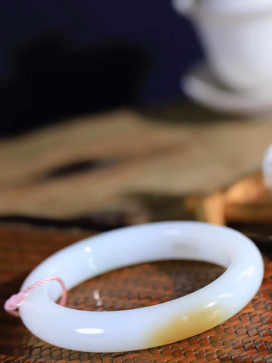 （一见倾心.手镯）

精品和田玉糖白玉手镯，玉质温润细腻 油性十足 手感舒适，高华雅逸，线条流畅，简约大气，美自天成，素雅高贵。佩戴于腕间，婉约之美，举手投足间透出那低调奢华。重68.2克  尺寸60.5-12.5-10mm  56401136A