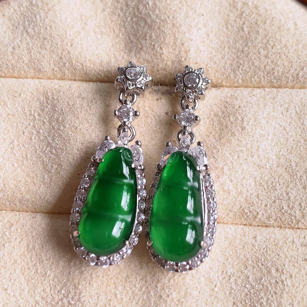 冰满绿翡翠925银镶嵌福豆耳坠，自然光实拍，翠色灵动，颜色漂亮，种老水足，品相佳，佩戴佳品！W481.11  取一整体尺寸：24.5-8.8-6.3mm  裸石尺寸：13-6.8mm