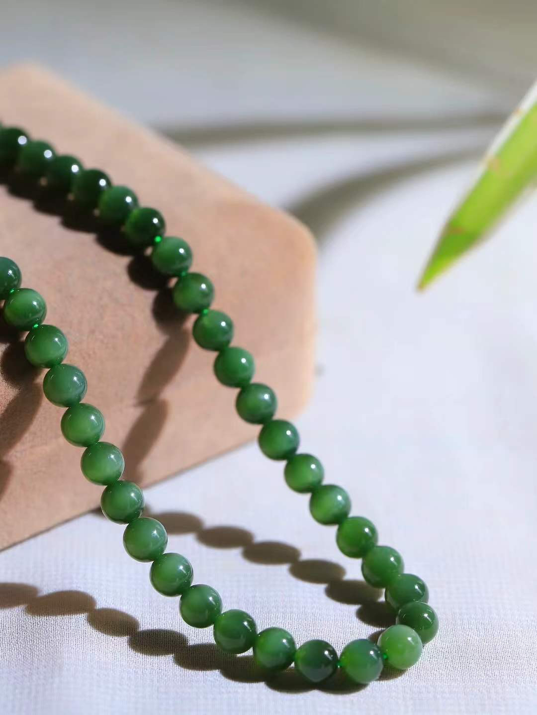 【珠圆玉润.项链】

精品和田玉碧玉猫眼珠圆玉润项链。这串碧玉项链垂落颈间，如把一汪春山绿意轻挽在身。玉色温润，每一颗圆珠都裹着圆满如意的期许，仿金扣轻缀，不事张扬却自有风骨。日常佩戴，是与草木同息的诗意，也是藏在细节里的安然与欢喜。重38.6克  尺寸取一5.9mm  21401466T