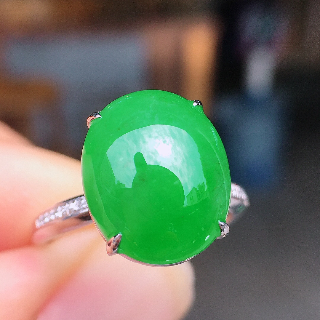 阳绿蛋面戒指，色泽均匀艳丽，玉质细腻，荧光感超
强，饱满圆润，尽显优雅气质，18k
金豪华镶嵌