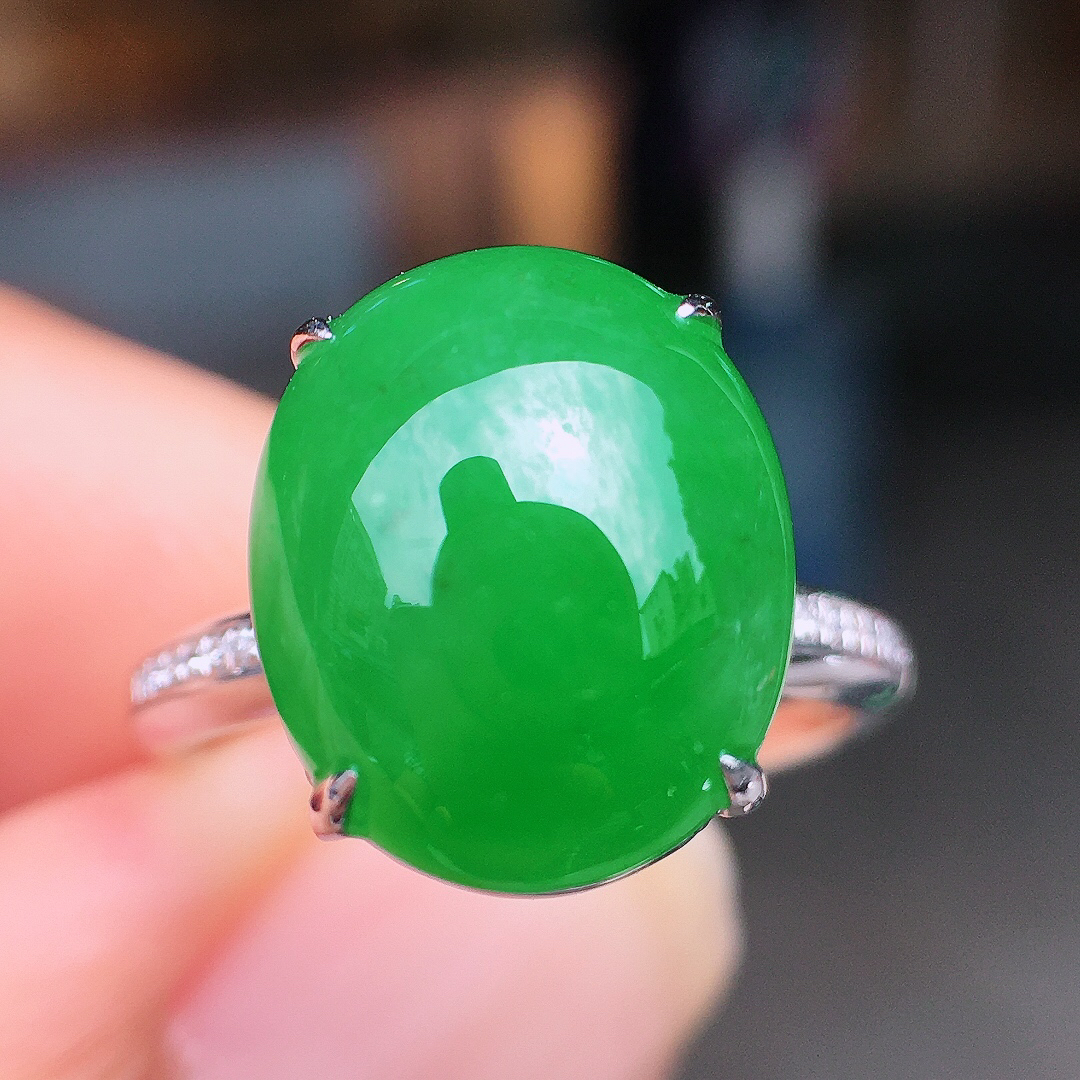 阳绿蛋面戒指，色泽均匀艳丽，玉质细腻，荧光感超
强，饱满圆润，尽显优雅气质，18k
金豪华镶嵌