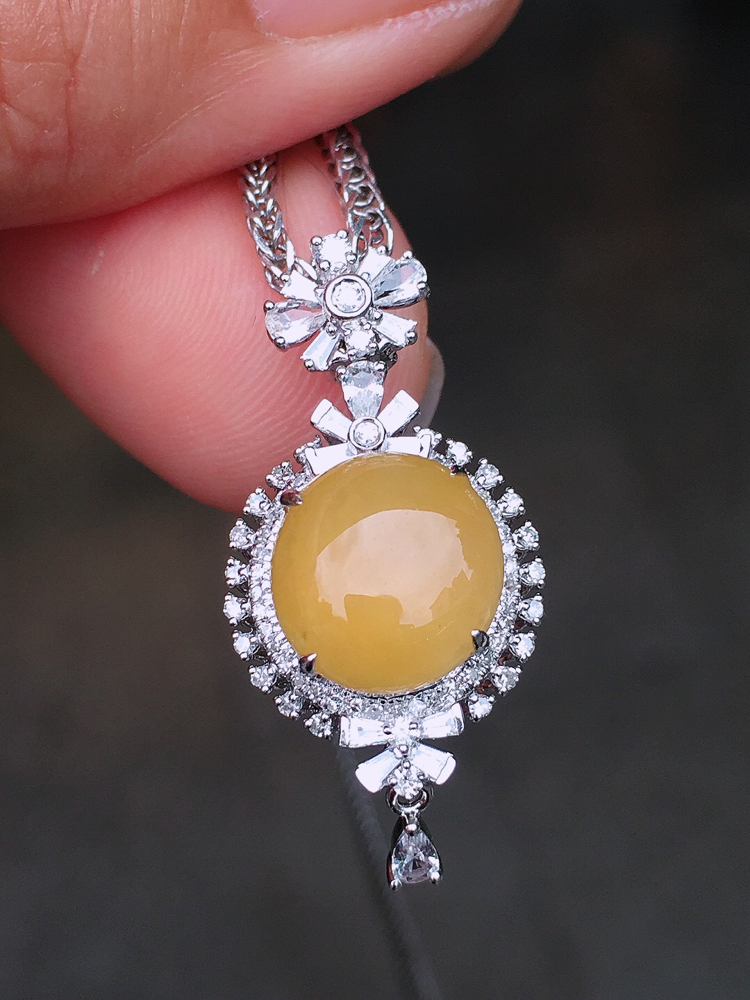 黄翡蛋面吊坠，色泽均匀艳丽，玉质细腻，荧光感超
强，饱满圆润，尽显优雅气质，18k
金豪华镶嵌