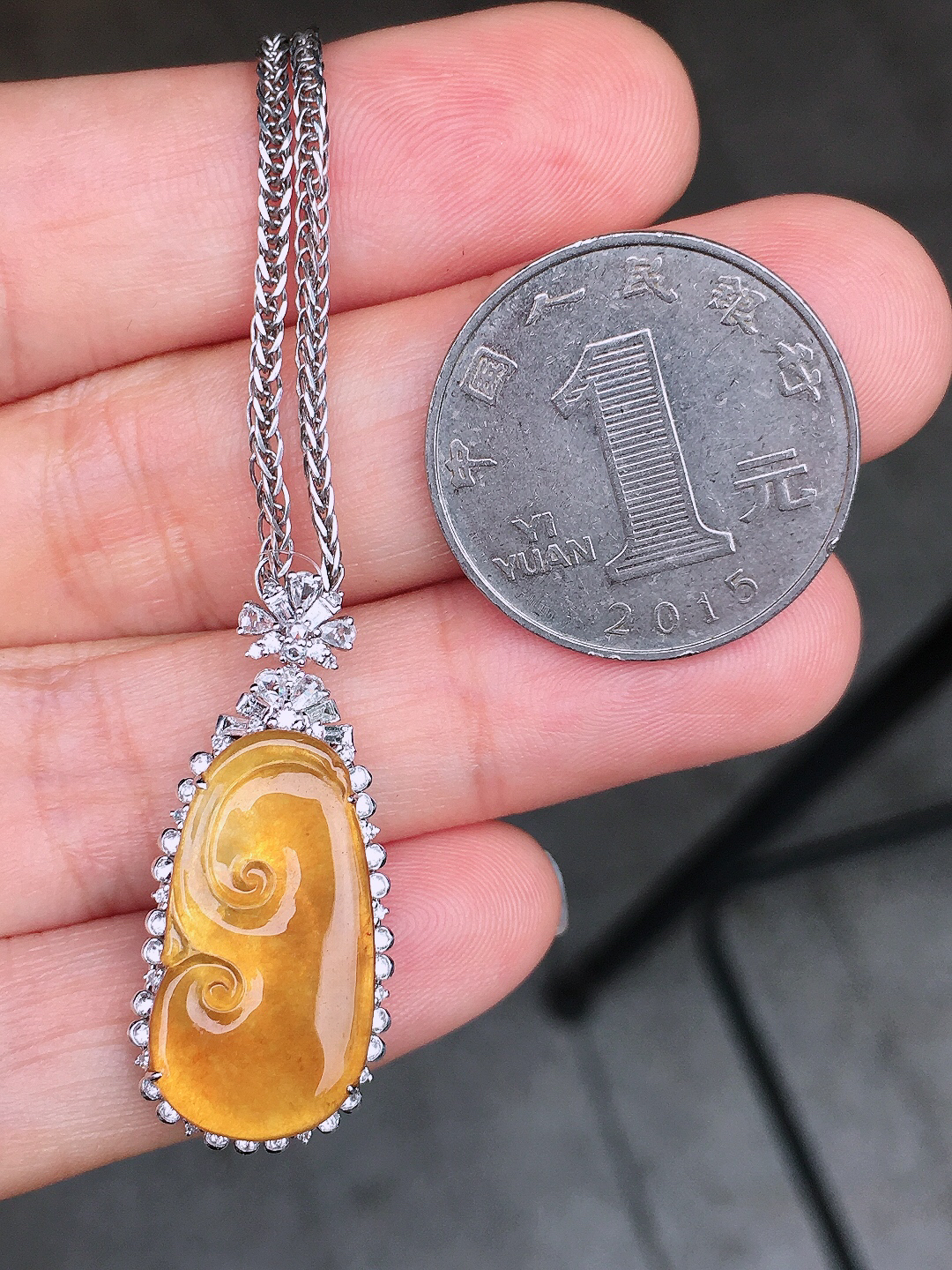 黄翡如意吊坠，色泽均匀艳丽，玉质细腻，荧光感超
强，饱满圆润，尽显优雅气质，18k
金豪华镶嵌