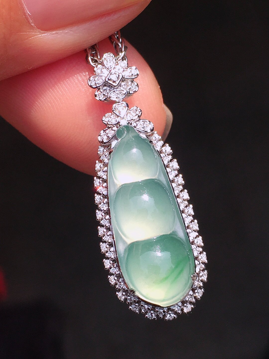 冰种福豆吊坠，色泽均匀艳丽，玉质细腻，荧光感超
强，饱满圆润，尽显优雅气质，18k
金豪华镶嵌