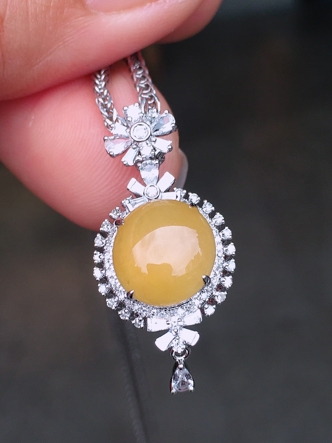 黄翡蛋面吊坠，色泽均匀艳丽，玉质细腻，荧光感超
强，饱满圆润，尽显优雅气质，18k
金豪华镶嵌