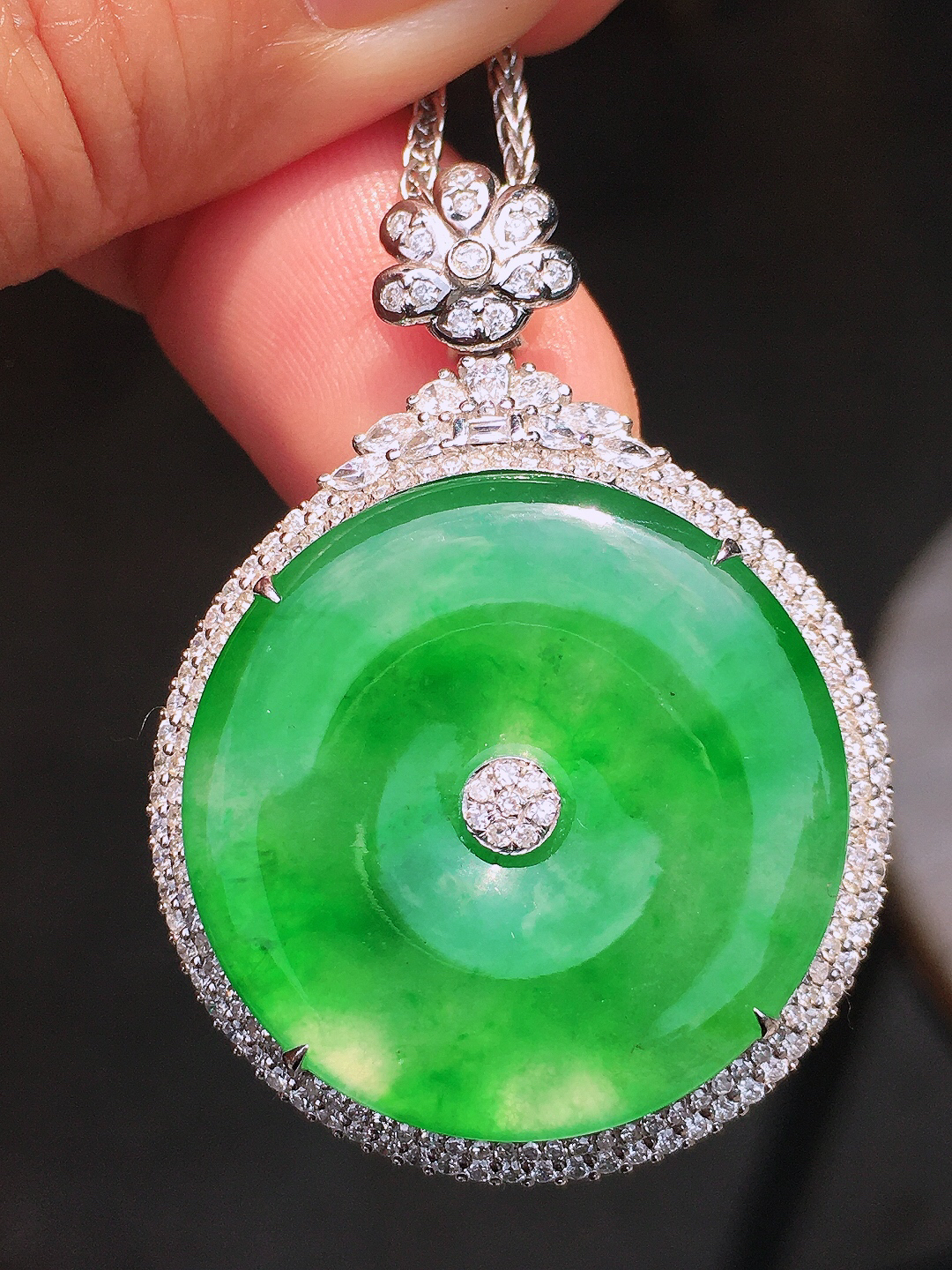 阳绿平安扣吊坠，色泽均匀艳丽，玉质细腻，荧光感超
强，饱满圆润，尽显优雅气质，18k
金豪华镶嵌