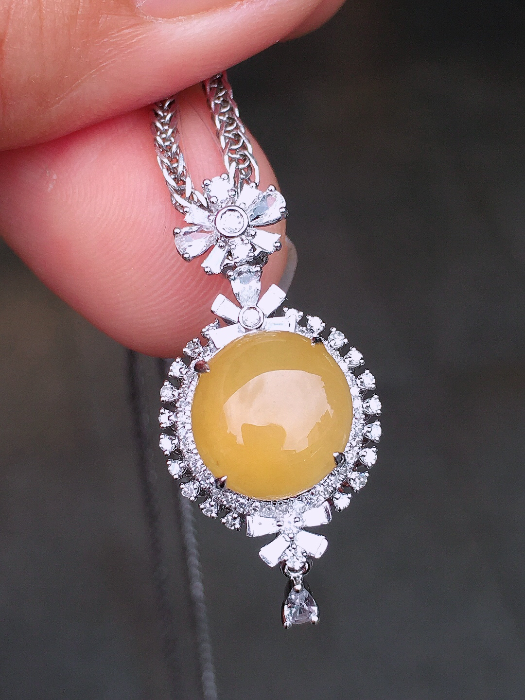 黄翡蛋面吊坠，色泽均匀艳丽，玉质细腻，荧光感超
强，饱满圆润，尽显优雅气质，18k
金豪华镶嵌