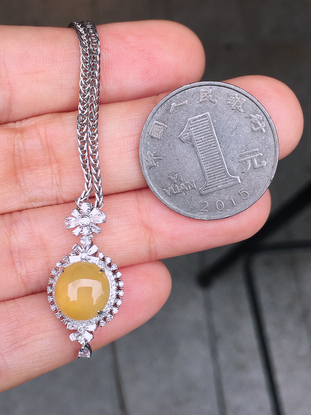 黄翡蛋面吊坠，色泽均匀艳丽，玉质细腻，荧光感超
强，饱满圆润，尽显优雅气质，18k
金豪华镶嵌