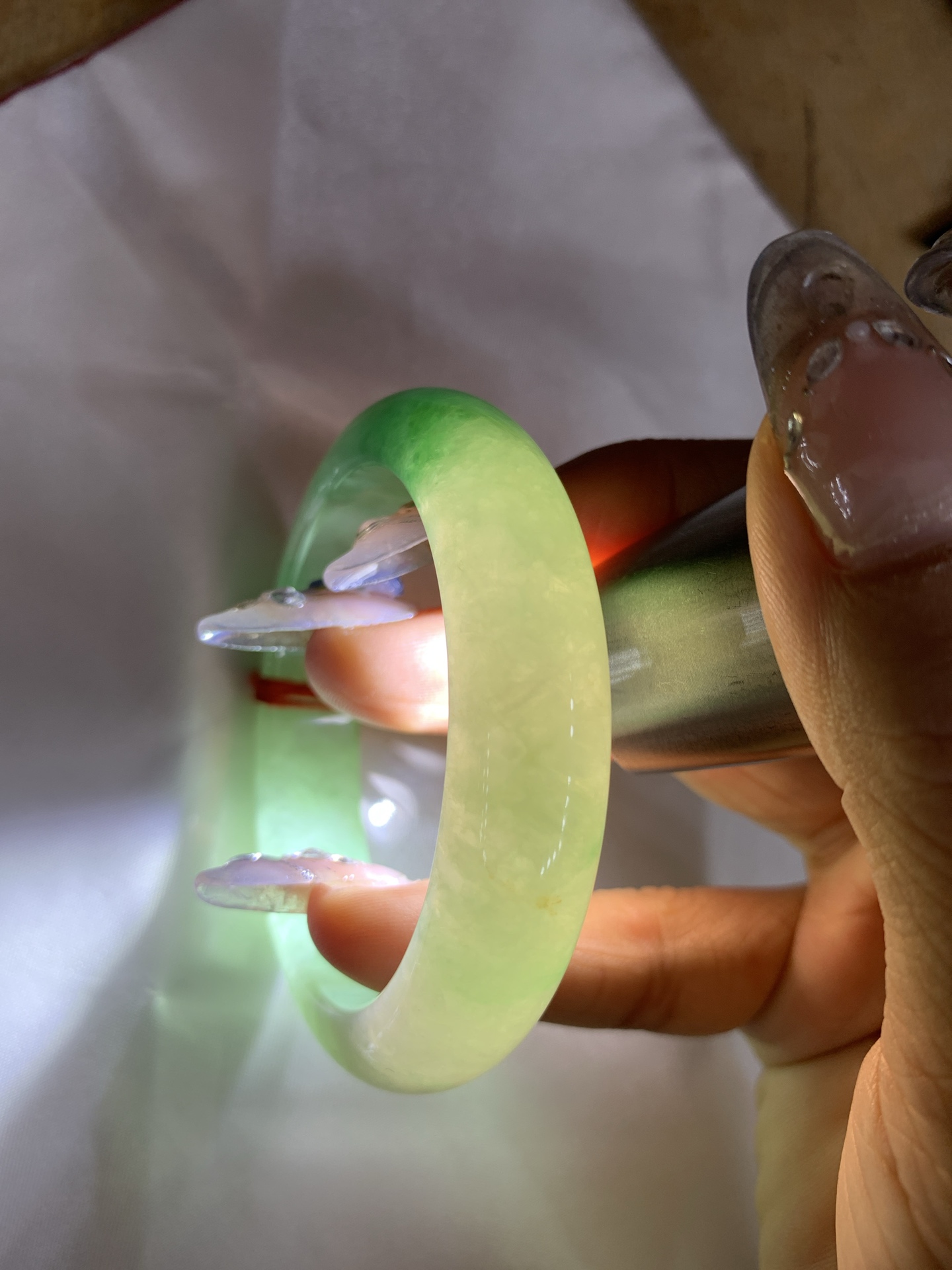 阳绿半山水正圈51-8.1-12.60419-N486打灯棉根，底妆冰润，半圈阳绿像春芽，从水润如晨露的底子蹦跳而出，将春日的灵动生机凝于手镯中，戴上她，清水芙蓉般的清新感自然晕染，每一次抬手，都似把盎然绿意融入生活。