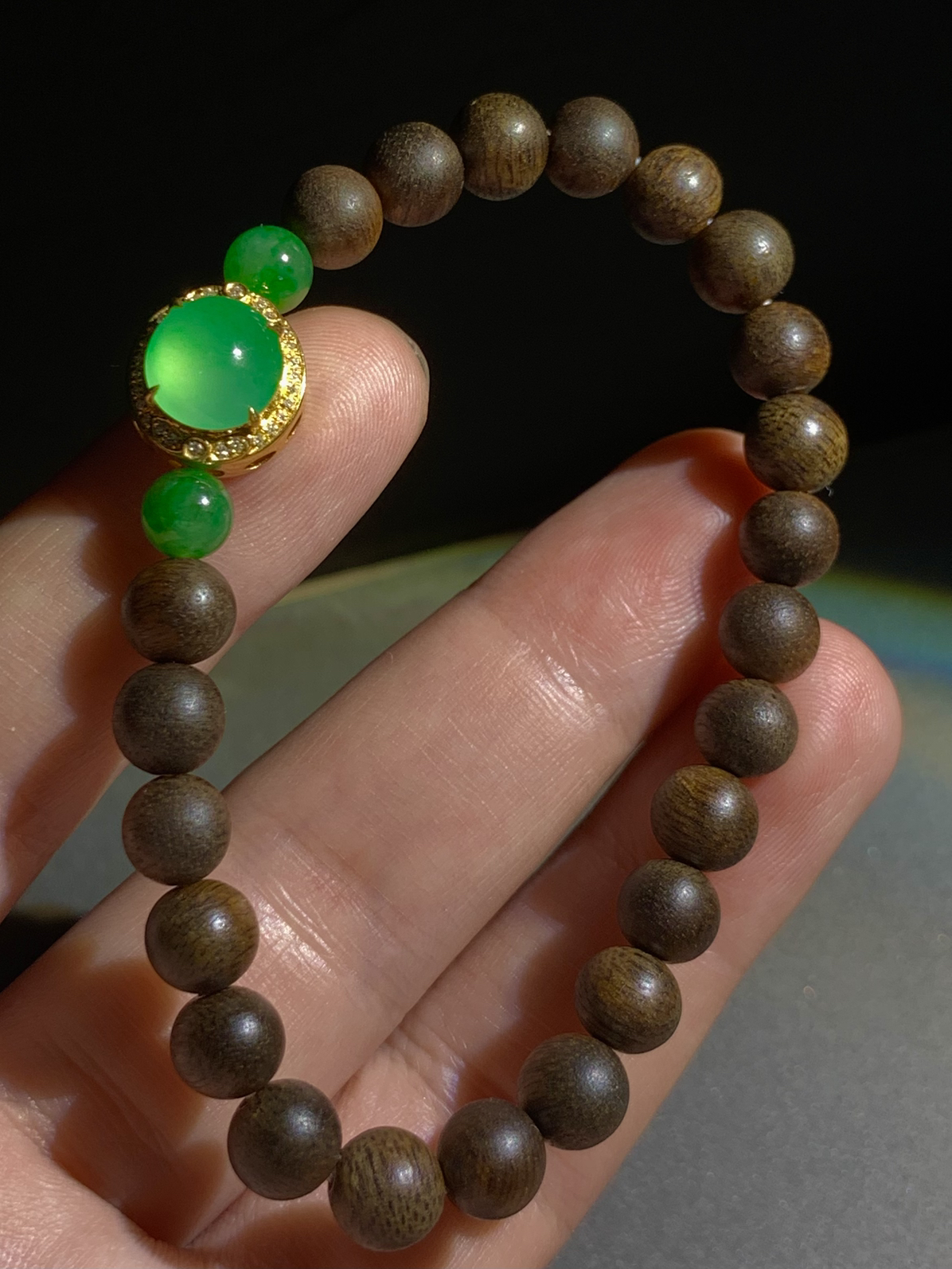 手链手串，翡翠绿蛋面裸石约9.2-8.6-4mm，
整体12.5-11.5-8.8mm，18K金，南非钻，
两粒翡翠绿珠，23粒沉香木珠7.2mm
