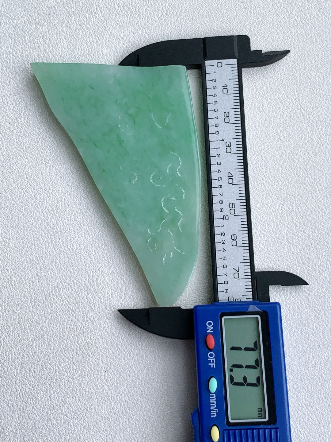 飘绿花/牌子料/片料/板料/特色料，可做牌子、人物、山水、动物、花件……等推荐参考，77.3-55-6.8，49克，烟青漫染春山色，柔翠轻铺玉骨温，这块冰润飘绿翡翠随形片料，底色清润通透、如春水漾漾般柔和匀净，鲜灵翠色如烟云晕染、丝丝缕缕灵动铺散，玉质细腻油润、水头莹亮饱满，肌理温润细腻，稍加匠心俏色巧雕，便可随形打磨为山水意境牌、自在禅佛、清雅花鸟等别致挂件，漫染翠意寓意生机盎然、前程舒展顺遂，温润玉底象征心境安然、福气绵长绵延自带清逸悠然的温婉气韵，佩戴之间衬得气质清雅脱俗，亦护佑一生安稳无忧、福禄常伴、万事称心明朗。