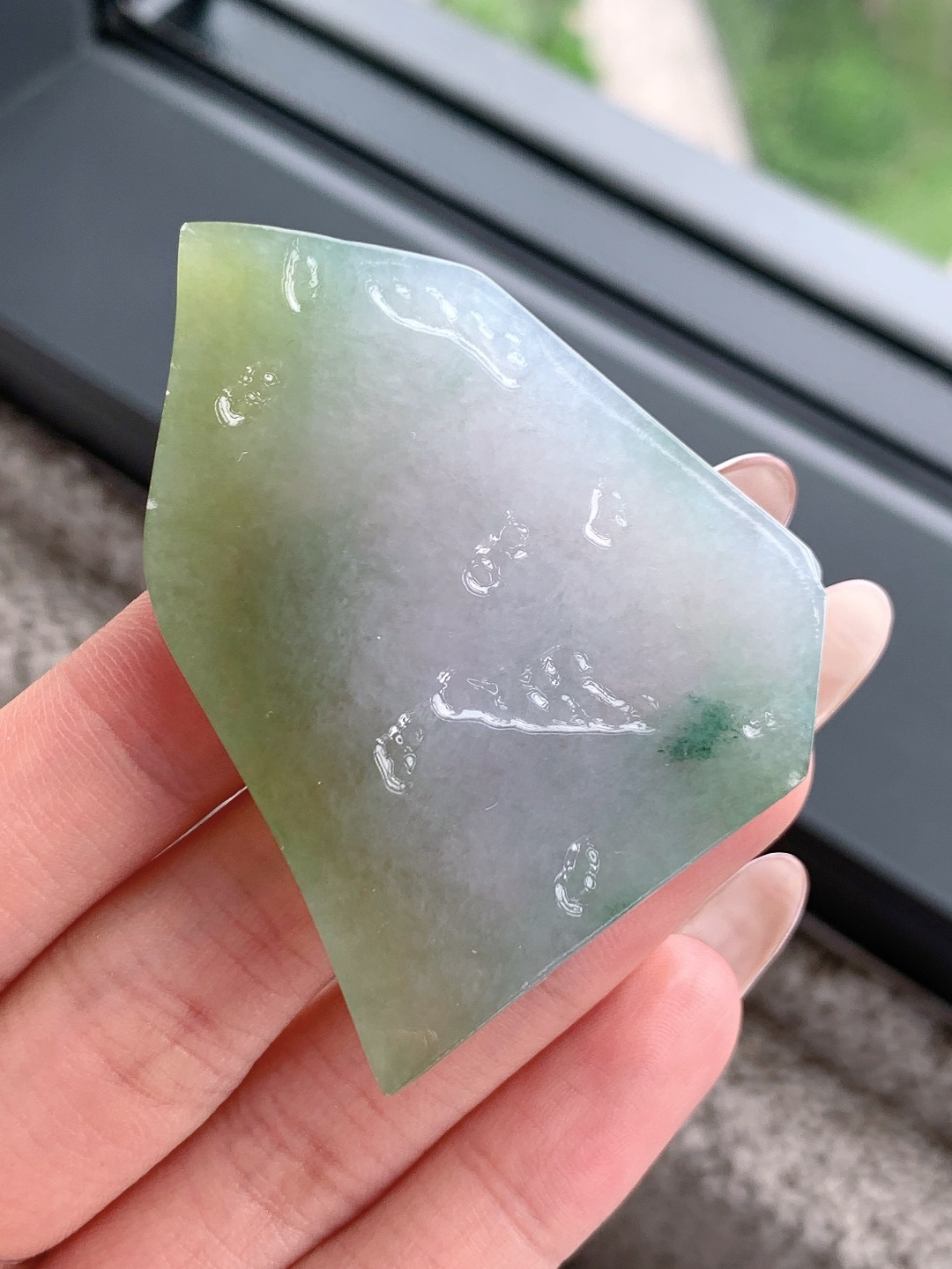 冰晴绿/冰飘花/牌子料/片料/板料/特色料，可做牌子、人物、山水、动物、花件……等推荐参考，61.5-44.9-7.4，43克，山衔浅黛凝清露，玉染轻烟蕴翠痕，这块冰润晴底带彩翡翠料子，底色温润通透如月光铺洒，边角晕染暖柔浅黄，一抹飘花翠色灵秀点缀其间，玉质细腻莹亮、水头充盈饱满，稍加匠心俏色精雕，便可化作山水意境牌、平安无事牌、悟道禅意挂件等雅致形制，浅暖翡色寓意温润纳福、和顺长久，点点翠花象征生机盎然、顺遂无忧自带清逸空灵的静谧氛围感，佩戴间衬得气质温润淡然，亦承载着山河安然、岁岁平顺、福运绵长的美好祈愿。