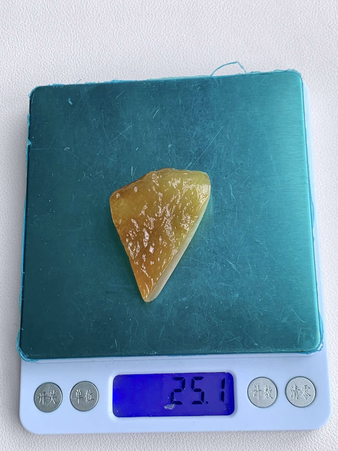 冰黄翡/随形料/立体料/特色料，可做随形件、人物、山水、动物、花件……等推荐参考，50-35.6-16，25.1克，蜜色凝金浮暖韵，玉肌蕴润自流光，这块满黄翡翡翠原石毛料，通体凝裹醇厚温润的蜜糖暖黄，玉质细腻油润、水头莹润亮泽，原生石面肌理饱满、胶感十足，稍加匠心俏色巧雕，便可随形打磨为貔貅、金蟾、福瓜、无事牌等各类招财雅致挂件，浓正黄翡自带金玉满堂、黄金满盈的贵气寓意，主招财纳宝、聚守财运、福禄绵延气韵温润厚重、贵而不骄，上手佩戴尽显沉稳气场，更护佑财源滚滚、运势兴旺、岁岁富足无忧。