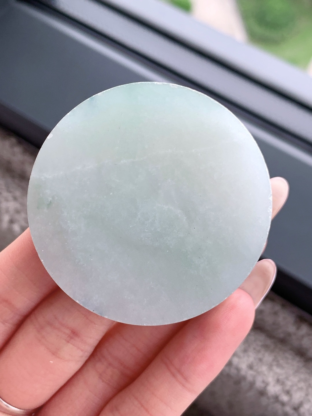 冰飘花 /牌子料/镯心料/特色料，可做牌子、人物、山水、动物、花件……等推荐参考，52.2-13.9，96.4克，材料优选，一圆清月凝冰魄，一缕飘翠画山川，这枚冰飘花翡翠圆牌胚料，质地温润莹净、水头灵透清亮，底色如月光铺洒般柔和淡雅，一抹浓绿飘花如远山含黛、似流水行舟，在素净玉面晕染出写意山水般的灵动意境，玉肉细腻胶润、品相规整圆满，稍加匠心雕琢，便可打磨成平安无事圆牌、怀古素圈、意境山水圆佩等雅致挂件，圆形象征圆满顺遂、团圆无忧，灵动飘花寓意前程舒展、生机绵延、福气生生不息气韵沉静温婉，佩戴可护佑岁岁平安、万事周全、福运圆圆满满、一生安稳无忧。