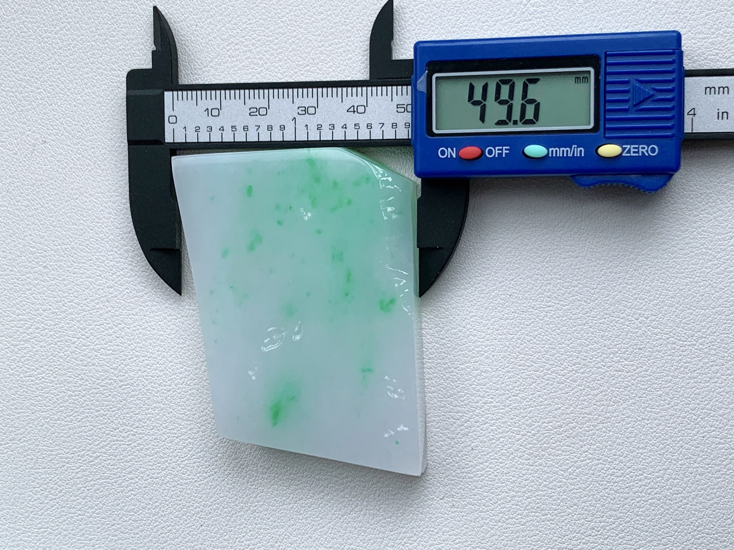 飘绿花/冰飘花/牌子料/片料/板料/特色料，可做牌子、人物、山水、动物、花件……等推荐参考，67.7-49.6-10.8，87.3克，材料优选，白底凝霜藏清润，翠点浮星蕴生机，这件白底青翡翠片料，底色莹白胜霜、细腻致密，如素绢般洁净温润，一抹抹阳绿灵动点缀、似星雨散落其间，色根鲜明、鲜阳灵动水头充足、胶感满满，经精工随形俏色雕琢，可打造为平安无事素牌、清雅山水牌、灵动瑞兽挂件等雅致佳作，白底寓意清净安宁、护主、顺遂无忧，翠点象征生机常伴、财运亨通、福禄常驻自带清新明快的氛围感，上手佩戴清爽百搭，既显温润雅致的气质，更承载着岁岁安康、前程明朗、福运绵延的美好祈愿。