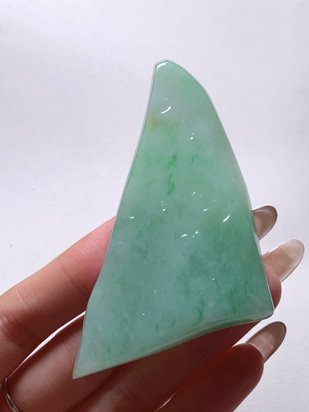 飘绿花/牌子料/片料/板料/特色料，可做牌子、人物、山水、动物、花件……等推荐参考，77.3-55-6.8，49克，烟青漫染春山色，柔翠轻铺玉骨温，这块冰润飘绿翡翠随形片料，底色清润通透、如春水漾漾般柔和匀净，鲜灵翠色如烟云晕染、丝丝缕缕灵动铺散，玉质细腻油润、水头莹亮饱满，肌理温润细腻，稍加匠心俏色巧雕，便可随形打磨为山水意境牌、自在禅佛、清雅花鸟等别致挂件，漫染翠意寓意生机盎然、前程舒展顺遂，温润玉底象征心境安然、福气绵长绵延自带清逸悠然的温婉气韵，佩戴之间衬得气质清雅脱俗，亦护佑一生安稳无忧、福禄常伴、万事称心明朗。