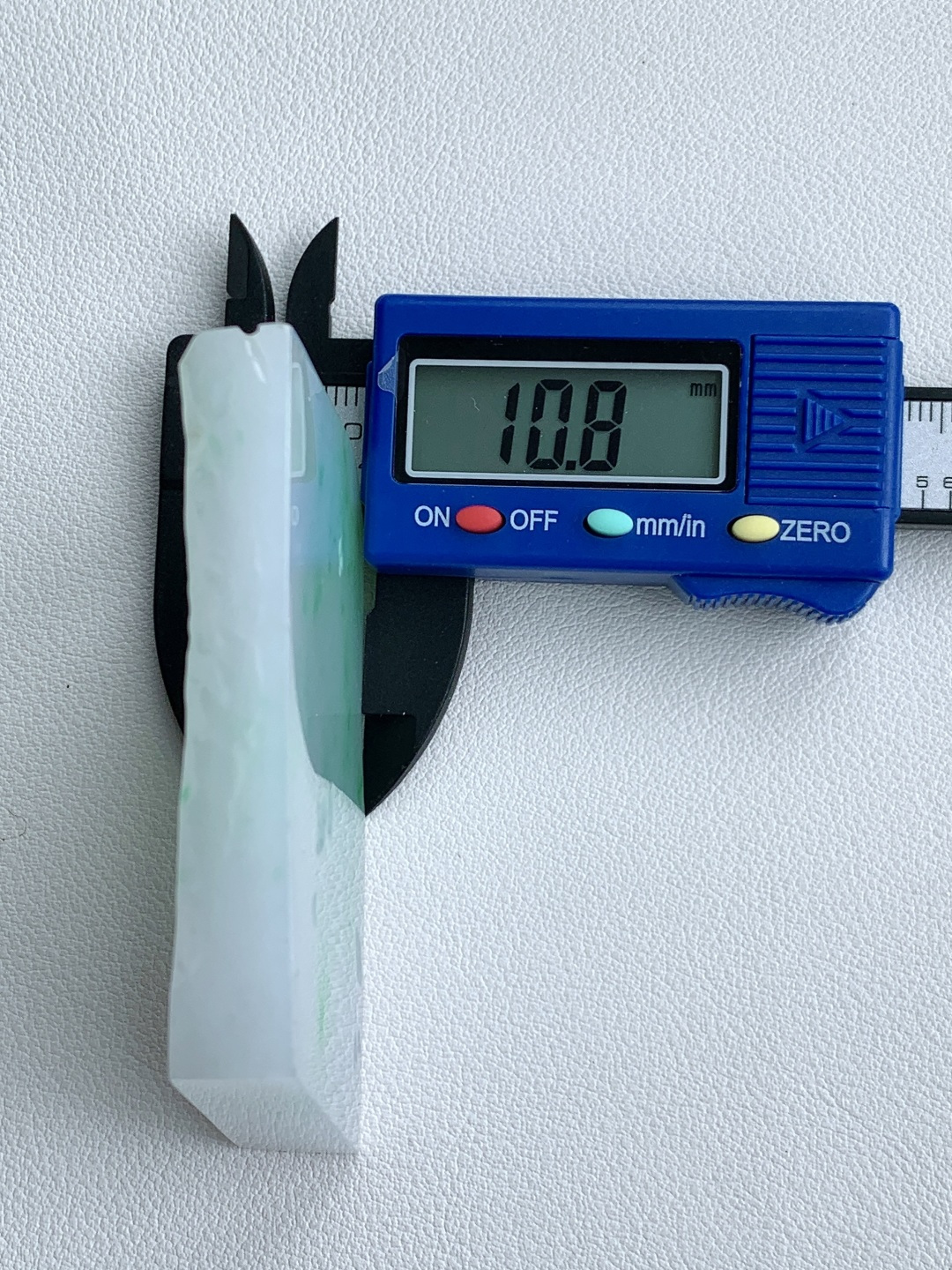 飘绿花/冰飘花/牌子料/片料/板料/特色料，可做牌子、人物、山水、动物、花件……等推荐参考，67.7-49.6-10.8，87.3克，材料优选，白底凝霜藏清润，翠点浮星蕴生机，这件白底青翡翠片料，底色莹白胜霜、细腻致密，如素绢般洁净温润，一抹抹阳绿灵动点缀、似星雨散落其间，色根鲜明、鲜阳灵动水头充足、胶感满满，经精工随形俏色雕琢，可打造为平安无事素牌、清雅山水牌、灵动瑞兽挂件等雅致佳作，白底寓意清净安宁、护主、顺遂无忧，翠点象征生机常伴、财运亨通、福禄常驻自带清新明快的氛围感，上手佩戴清爽百搭，既显温润雅致的气质，更承载着岁岁安康、前程明朗、福运绵延的美好祈愿。