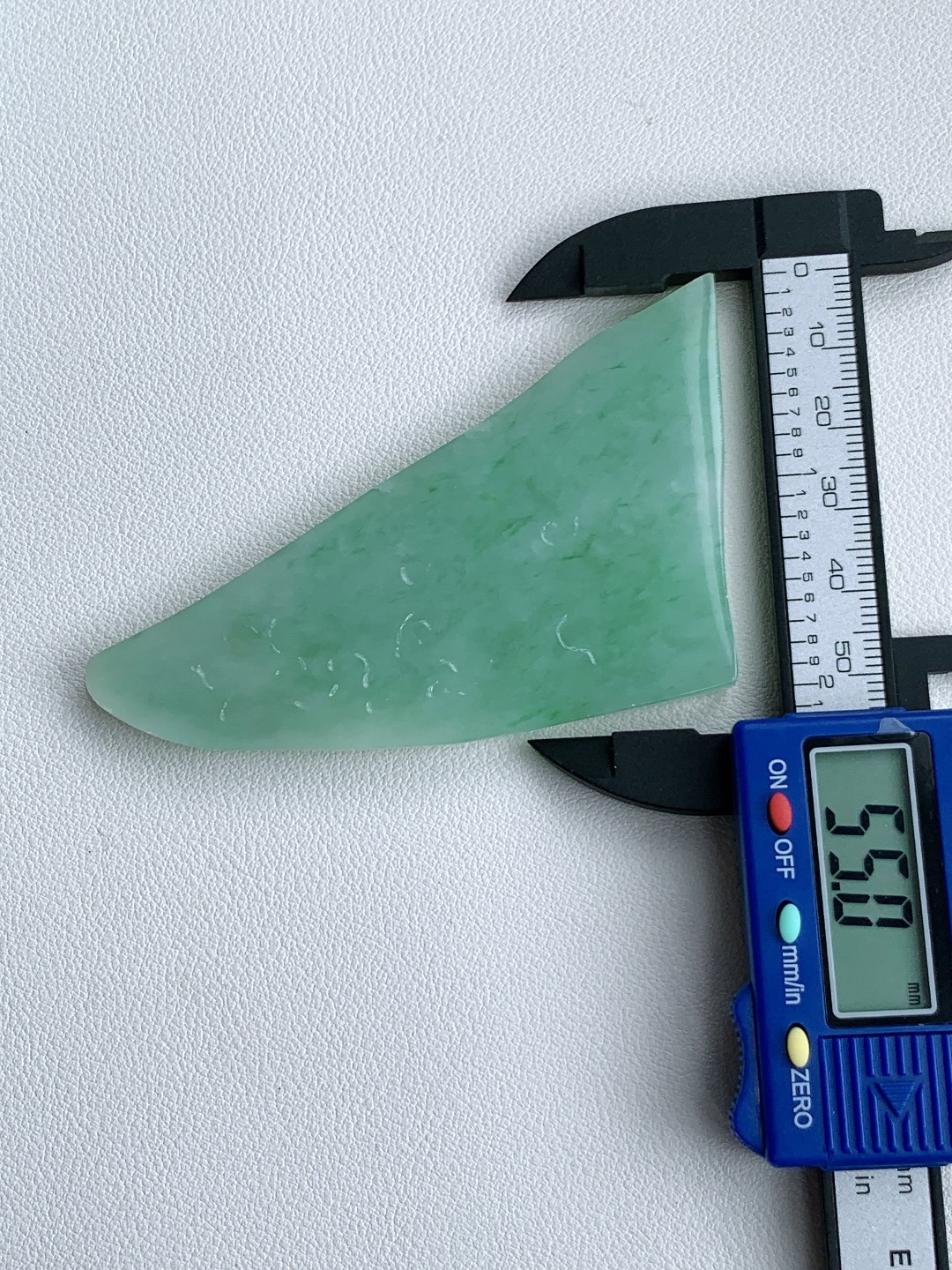 飘绿花/牌子料/片料/板料/特色料，可做牌子、人物、山水、动物、花件……等推荐参考，77.3-55-6.8，49克，烟青漫染春山色，柔翠轻铺玉骨温，这块冰润飘绿翡翠随形片料，底色清润通透、如春水漾漾般柔和匀净，鲜灵翠色如烟云晕染、丝丝缕缕灵动铺散，玉质细腻油润、水头莹亮饱满，肌理温润细腻，稍加匠心俏色巧雕，便可随形打磨为山水意境牌、自在禅佛、清雅花鸟等别致挂件，漫染翠意寓意生机盎然、前程舒展顺遂，温润玉底象征心境安然、福气绵长绵延自带清逸悠然的温婉气韵，佩戴之间衬得气质清雅脱俗，亦护佑一生安稳无忧、福禄常伴、万事称心明朗。