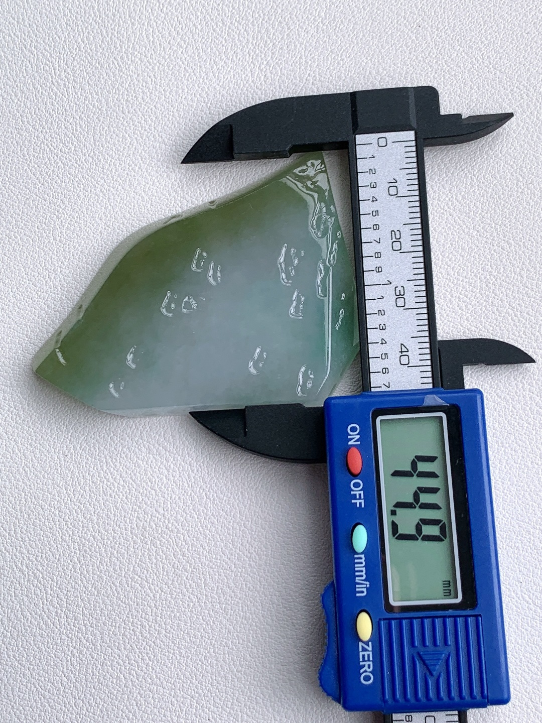 冰晴绿/冰飘花/牌子料/片料/板料/特色料，可做牌子、人物、山水、动物、花件……等推荐参考，61.5-44.9-7.4，43克，山衔浅黛凝清露，玉染轻烟蕴翠痕，这块冰润晴底带彩翡翠料子，底色温润通透如月光铺洒，边角晕染暖柔浅黄，一抹飘花翠色灵秀点缀其间，玉质细腻莹亮、水头充盈饱满，稍加匠心俏色精雕，便可化作山水意境牌、平安无事牌、悟道禅意挂件等雅致形制，浅暖翡色寓意温润纳福、和顺长久，点点翠花象征生机盎然、顺遂无忧自带清逸空灵的静谧氛围感，佩戴间衬得气质温润淡然，亦承载着山河安然、岁岁平顺、福运绵长的美好祈愿。