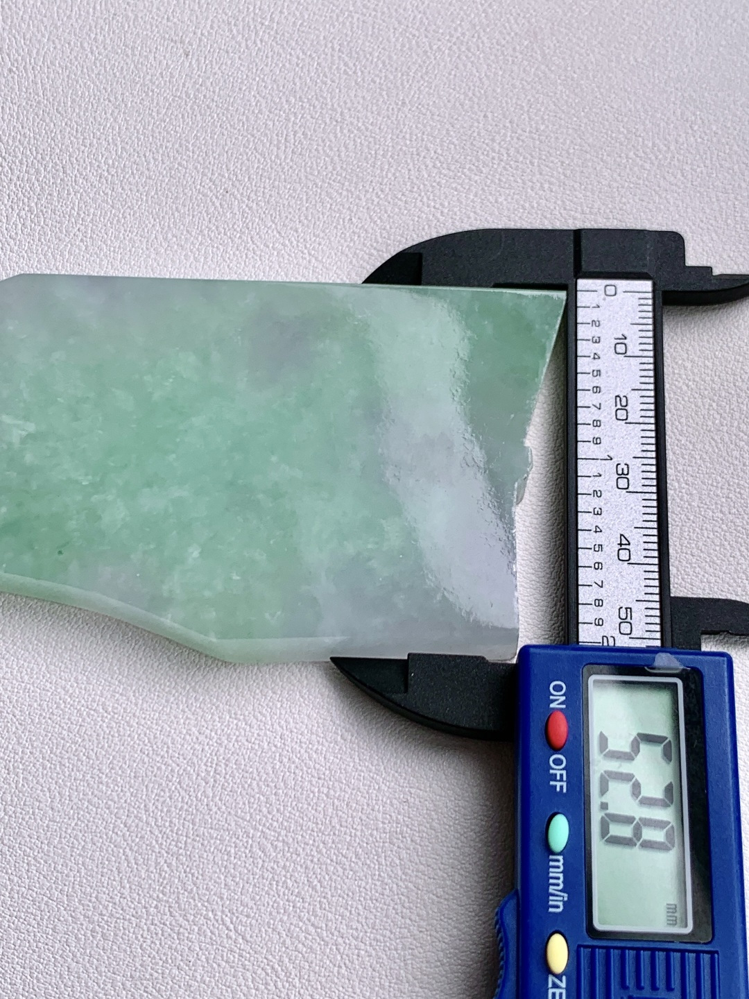 ️冰飘花/牌子料/片料/板料/特色料题材可做牌子、人物、山水、动物、花件……等推荐参考99.4-52.8-7.2107.8克材料优选厚装片料藏千意，一琢一成皆入禅。此料为冰春彩飘花大料胚，紫韵温婉，绿意灵动，冰质澄澈如月下流泉。厚装大料形制舒展，留白丰沛，既宜雕琢大件山水、人物摆件，呈恢弘意境；亦可拆分制牌，藏方寸雅趣。是集颜值与潜力于一身的匠心之选，承载“春满乾坤，紫气东来”的美好期许。