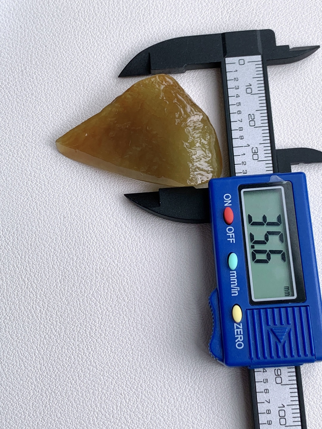 冰黄翡/随形料/立体料/特色料，可做随形件、人物、山水、动物、花件……等推荐参考，50-35.6-16，25.1克，蜜色凝金浮暖韵，玉肌蕴润自流光，这块满黄翡翡翠原石毛料，通体凝裹醇厚温润的蜜糖暖黄，玉质细腻油润、水头莹润亮泽，原生石面肌理饱满、胶感十足，稍加匠心俏色巧雕，便可随形打磨为貔貅、金蟾、福瓜、无事牌等各类招财雅致挂件，浓正黄翡自带金玉满堂、黄金满盈的贵气寓意，主招财纳宝、聚守财运、福禄绵延气韵温润厚重、贵而不骄，上手佩戴尽显沉稳气场，更护佑财源滚滚、运势兴旺、岁岁富足无忧。