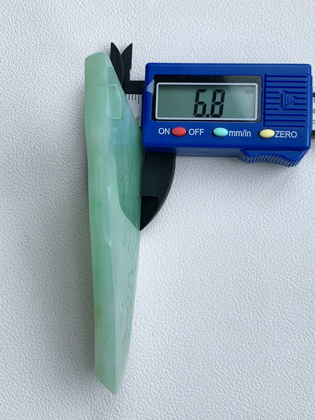 飘绿花/牌子料/片料/板料/特色料，可做牌子、人物、山水、动物、花件……等推荐参考，77.3-55-6.8，49克，烟青漫染春山色，柔翠轻铺玉骨温，这块冰润飘绿翡翠随形片料，底色清润通透、如春水漾漾般柔和匀净，鲜灵翠色如烟云晕染、丝丝缕缕灵动铺散，玉质细腻油润、水头莹亮饱满，肌理温润细腻，稍加匠心俏色巧雕，便可随形打磨为山水意境牌、自在禅佛、清雅花鸟等别致挂件，漫染翠意寓意生机盎然、前程舒展顺遂，温润玉底象征心境安然、福气绵长绵延自带清逸悠然的温婉气韵，佩戴之间衬得气质清雅脱俗，亦护佑一生安稳无忧、福禄常伴、万事称心明朗。