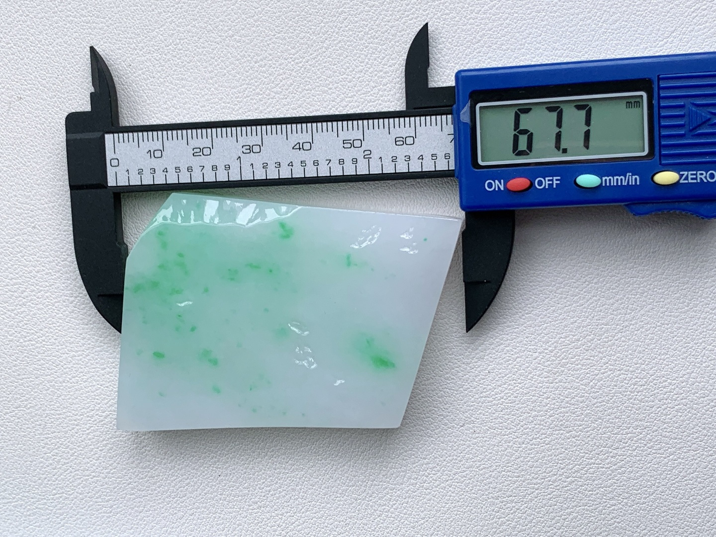 飘绿花/冰飘花/牌子料/片料/板料/特色料，可做牌子、人物、山水、动物、花件……等推荐参考，67.7-49.6-10.8，87.3克，材料优选，白底凝霜藏清润，翠点浮星蕴生机，这件白底青翡翠片料，底色莹白胜霜、细腻致密，如素绢般洁净温润，一抹抹阳绿灵动点缀、似星雨散落其间，色根鲜明、鲜阳灵动水头充足、胶感满满，经精工随形俏色雕琢，可打造为平安无事素牌、清雅山水牌、灵动瑞兽挂件等雅致佳作，白底寓意清净安宁、护主、顺遂无忧，翠点象征生机常伴、财运亨通、福禄常驻自带清新明快的氛围感，上手佩戴清爽百搭，既显温润雅致的气质，更承载着岁岁安康、前程明朗、福运绵延的美好祈愿。