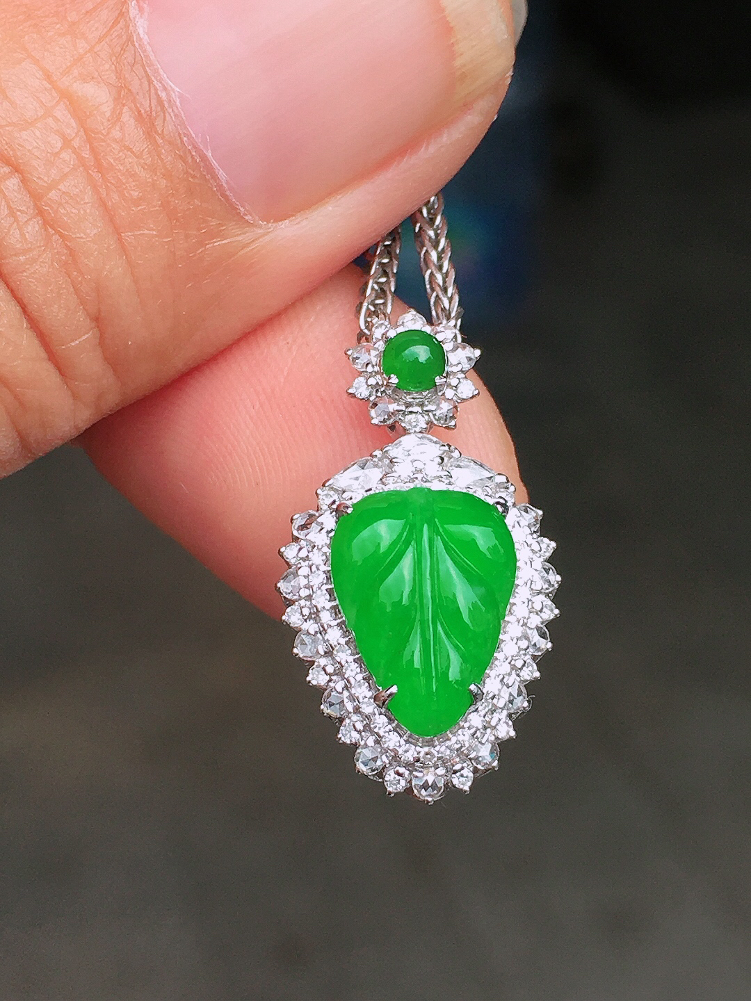 阳绿玉叶吊坠，色泽均匀艳丽，玉质细腻，荧光感超
强，饱满圆润，尽显优雅气质，18k
金豪华镶嵌