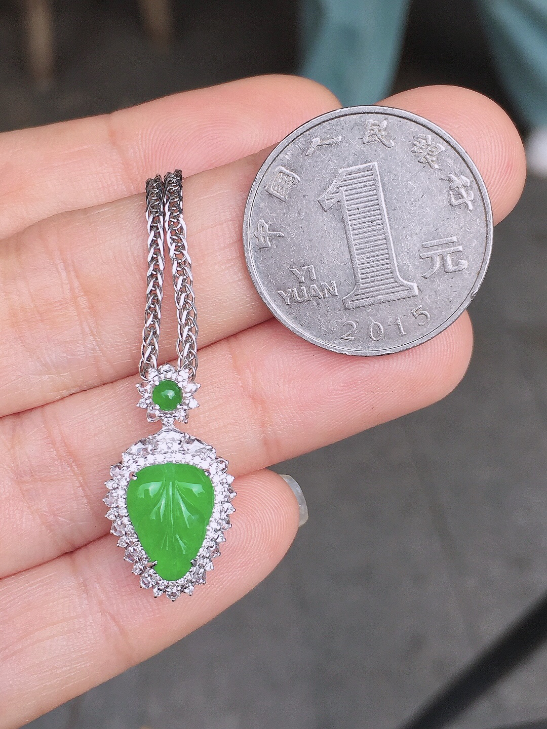 阳绿玉叶吊坠，色泽均匀艳丽，玉质细腻，荧光感超
强，饱满圆润，尽显优雅气质，18k
金豪华镶嵌