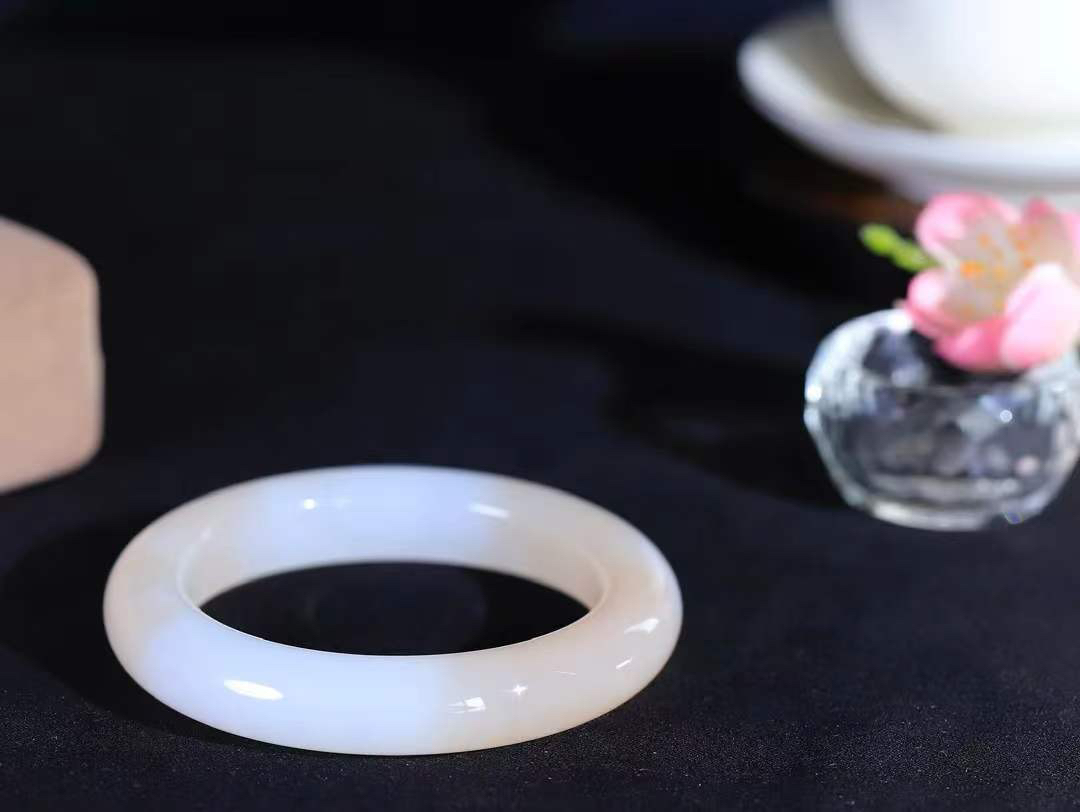 （一见倾心.手镯）

精品和田玉白玉藕粉双色手镯，玉质温润细腻 油性十足 手感舒适，高华雅逸，线条流畅，简约大气，美自天成，素雅高贵。佩戴于腕间，婉约之美，举手投足间透出那低调奢华。重64.5克  尺寸53.5-12.4-10.8mm  56401936A