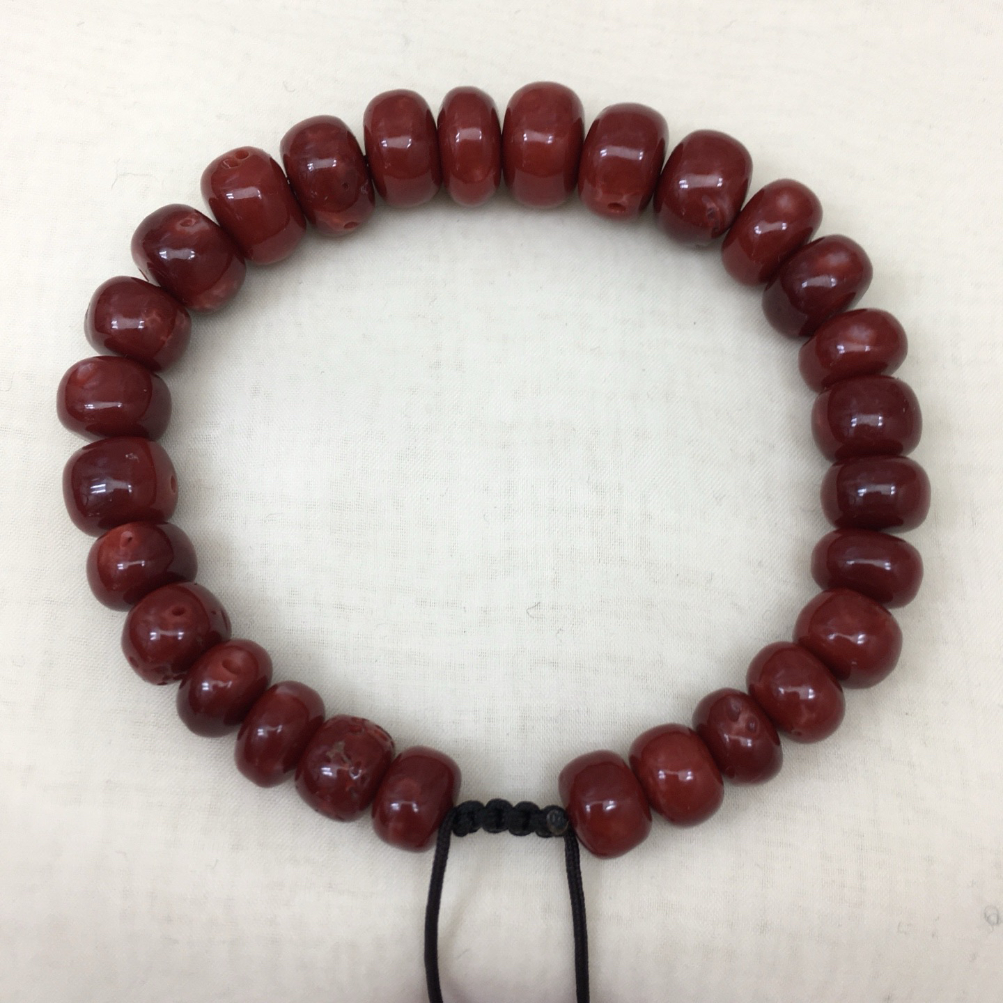 【天然日本阿卡赤血牛血红珊瑚11mm鼓珠单圈手串】天然无添加无优化，日本产地，阿卡材料、高瓷度，赤血牛血红颜色，珠子直径11-8.1mm，每颗珠子均为天然的珊瑚，珊瑚自古就为佛教珍宝，深海千年有机宝石！材料限制裸石有阿卡标志性白芯眼，收藏价值高、可传承！重量30.75克。