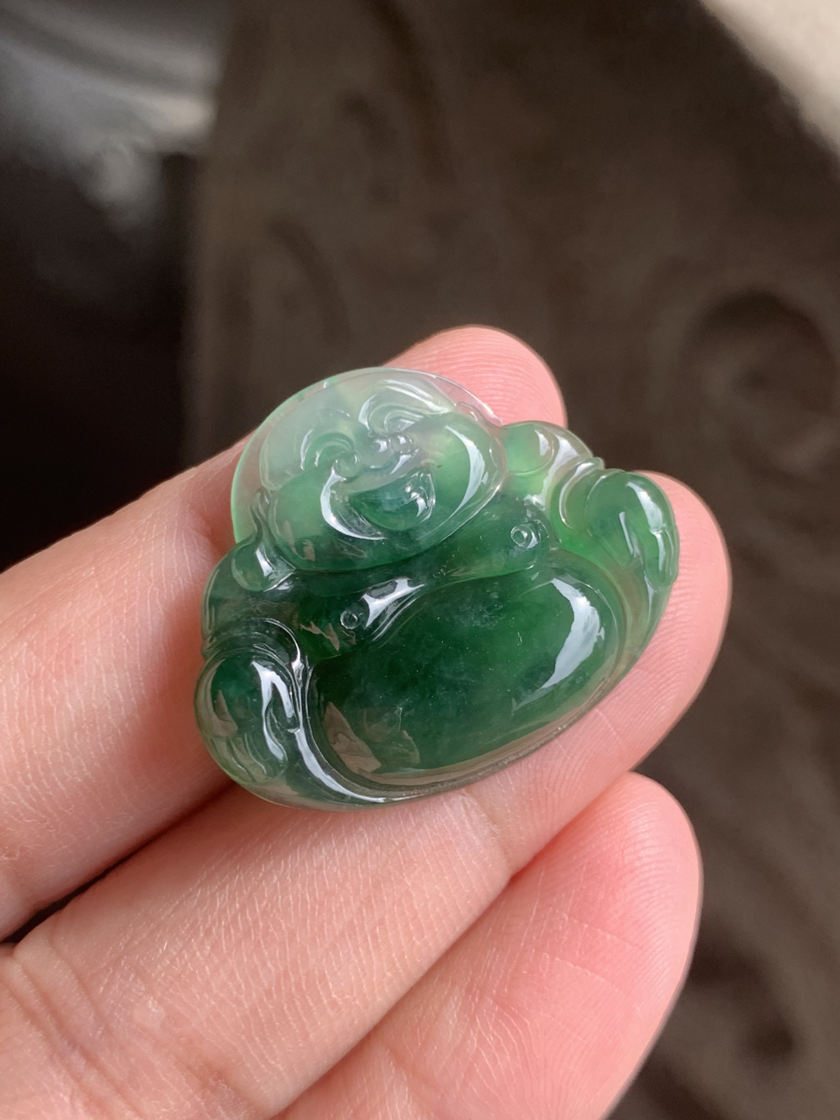 【冰油满绿佛公】吊坠，裸石尺寸24.5*30*5.2整体是冰种油绿的质地，水头足到透着柔光，玉质细腻莹润，绿调像被揉进了水光里，不艳不燥，是越看越有味道的油润质感。佛公的开脸是点睛之笔：眉眼弯弯，笑意盈盈，肚子圆润饱满，线条柔和讨喜，把“笑口常开、肚大能容”的福气都刻在了玉里。 背面右下角微表皮纹微扣